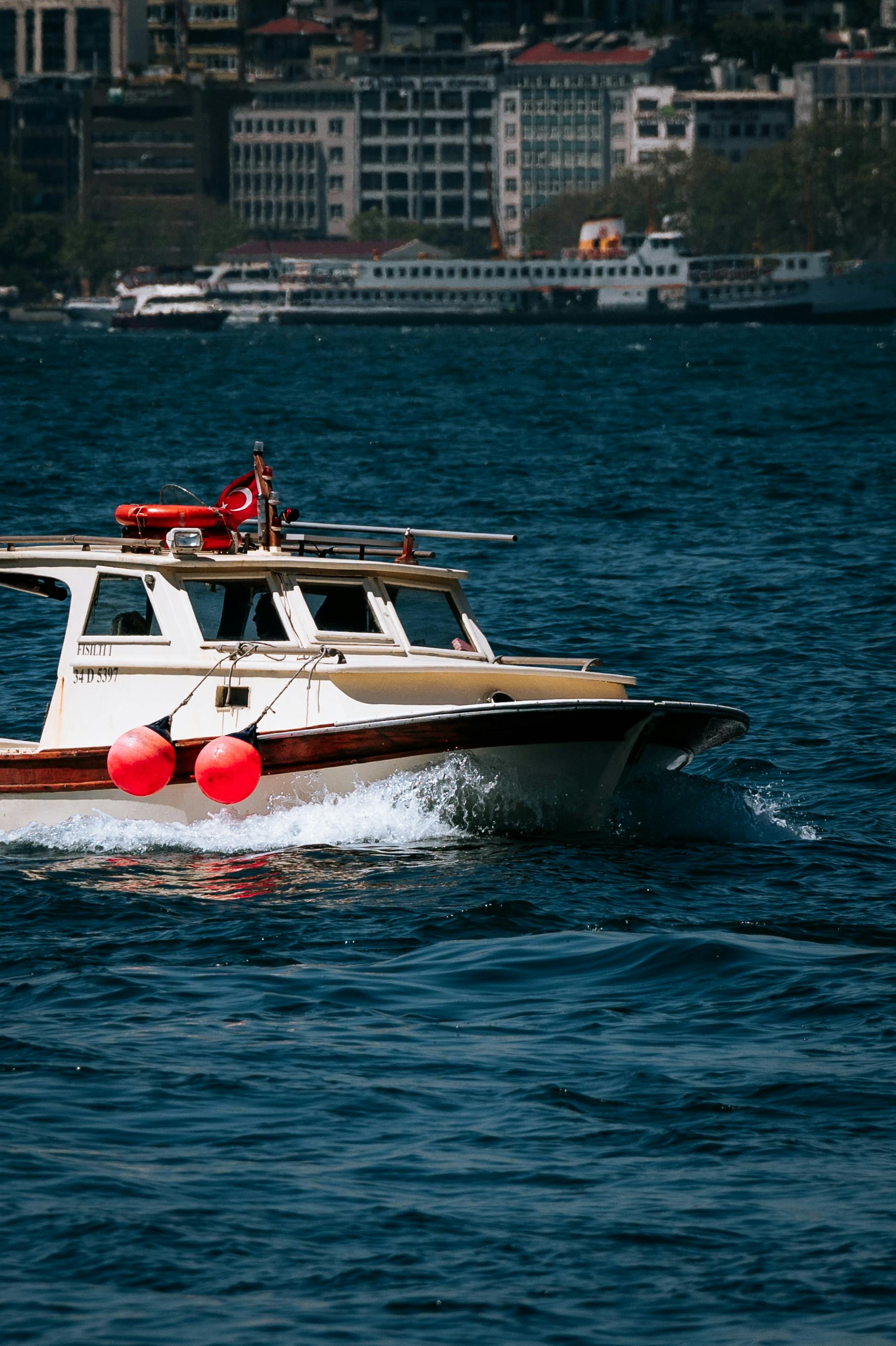 pexels-photo-32018527-32018527 A boat navigates the vibrant Bosphorus waters in Istanbul, Turkey, with a cityscape backdrop.